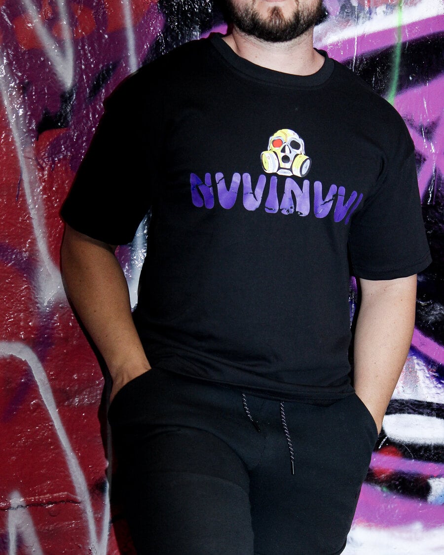 T-shirt noir VINV à impression violette porté, devant un mur de graffitis magenta