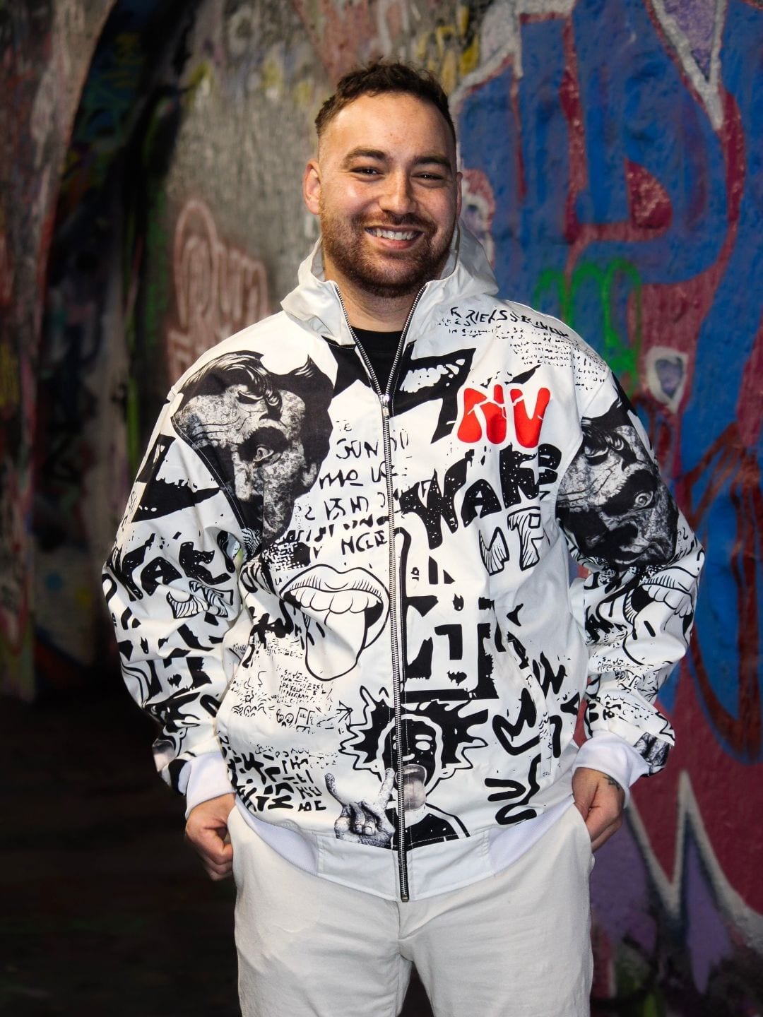 Veste graffiti blanche portée ouverte de face, graffiti noir et lettrage NVVINVVI rouge.
